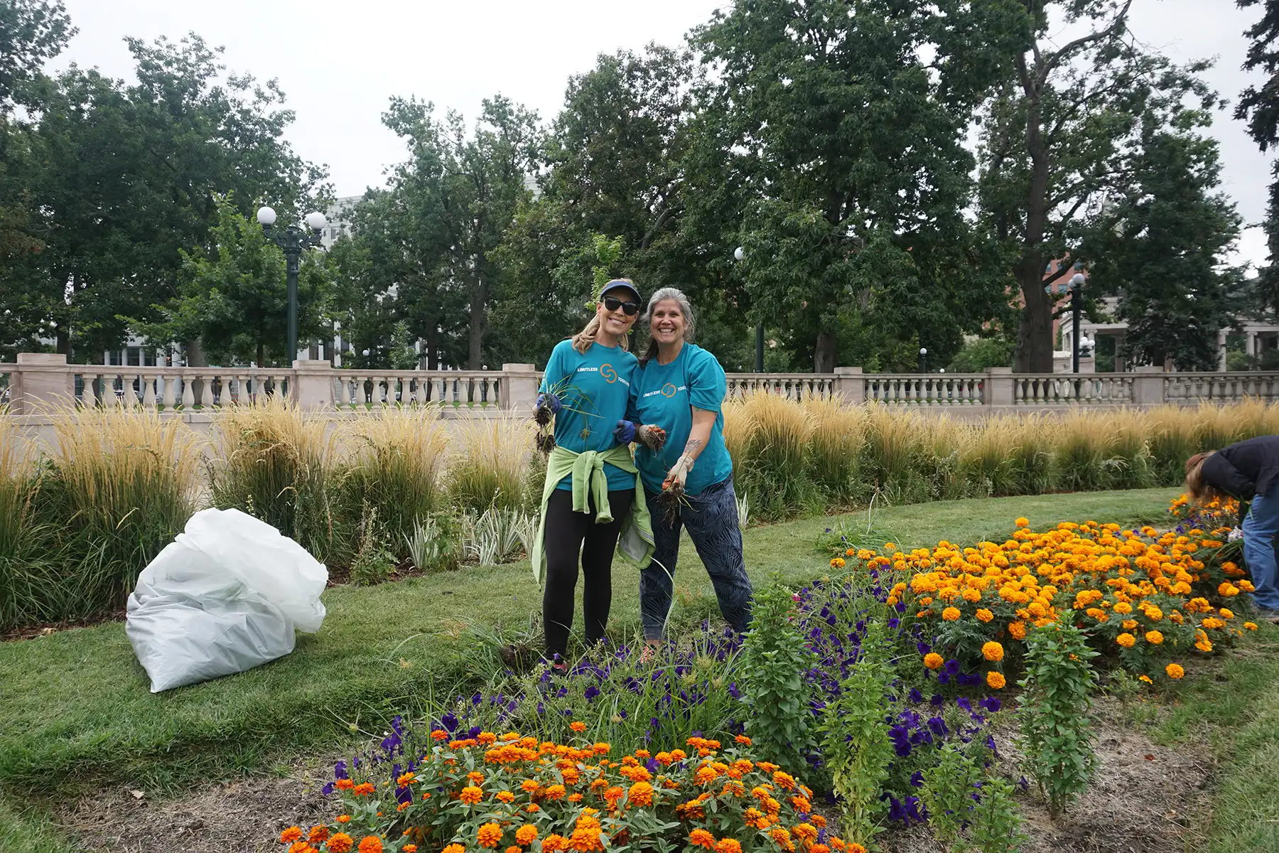 civic-center-volunteers Two volunteers cleaning up the park, stopping to pose for a photo